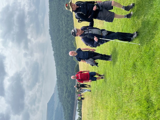 The group are spread out climbing a gentle hill away from the reservoir.
It's still quite cloudy but there is a little sunlight.